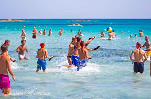 Jungen, die Spaß im Meer am Strand von Camping Cala Ginepro haben